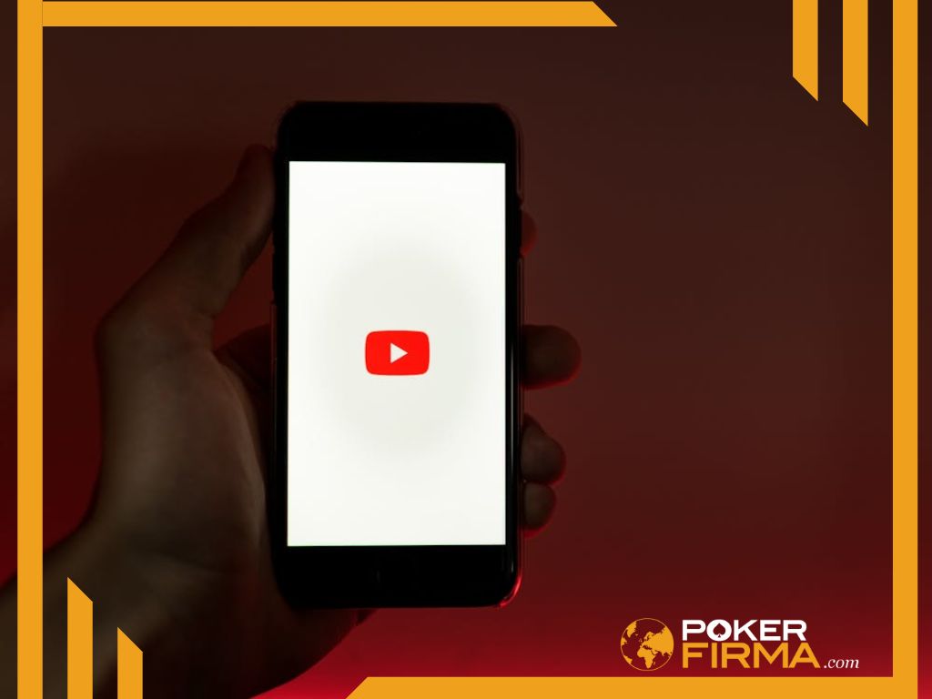 Person mit Smartphone mit YouTube Logo in der Hand