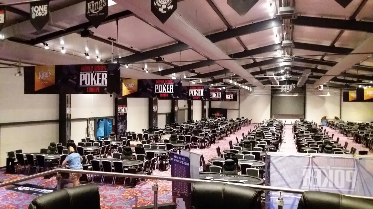 Ein großer Turniersaal mit zahlreichen Pokertischen und Bannern der World Series of Poker Europe.