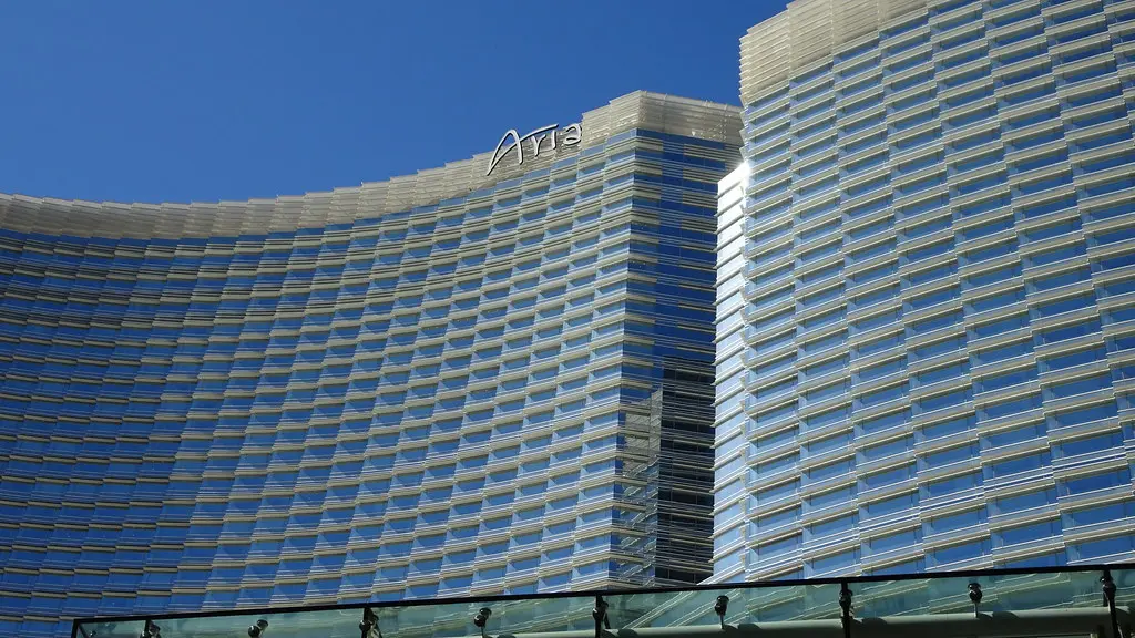 Die moderne Glasfassade des Aria Resort & Casino in Las Vegas unter einem blauen Himmel.