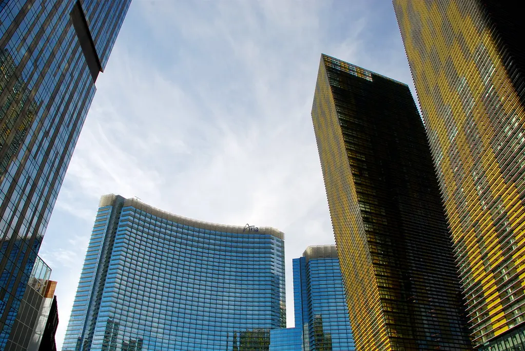 Die modernen Glasfassaden des ARIA Resort & Casino in Las Vegas unter einem hellen Himmel.