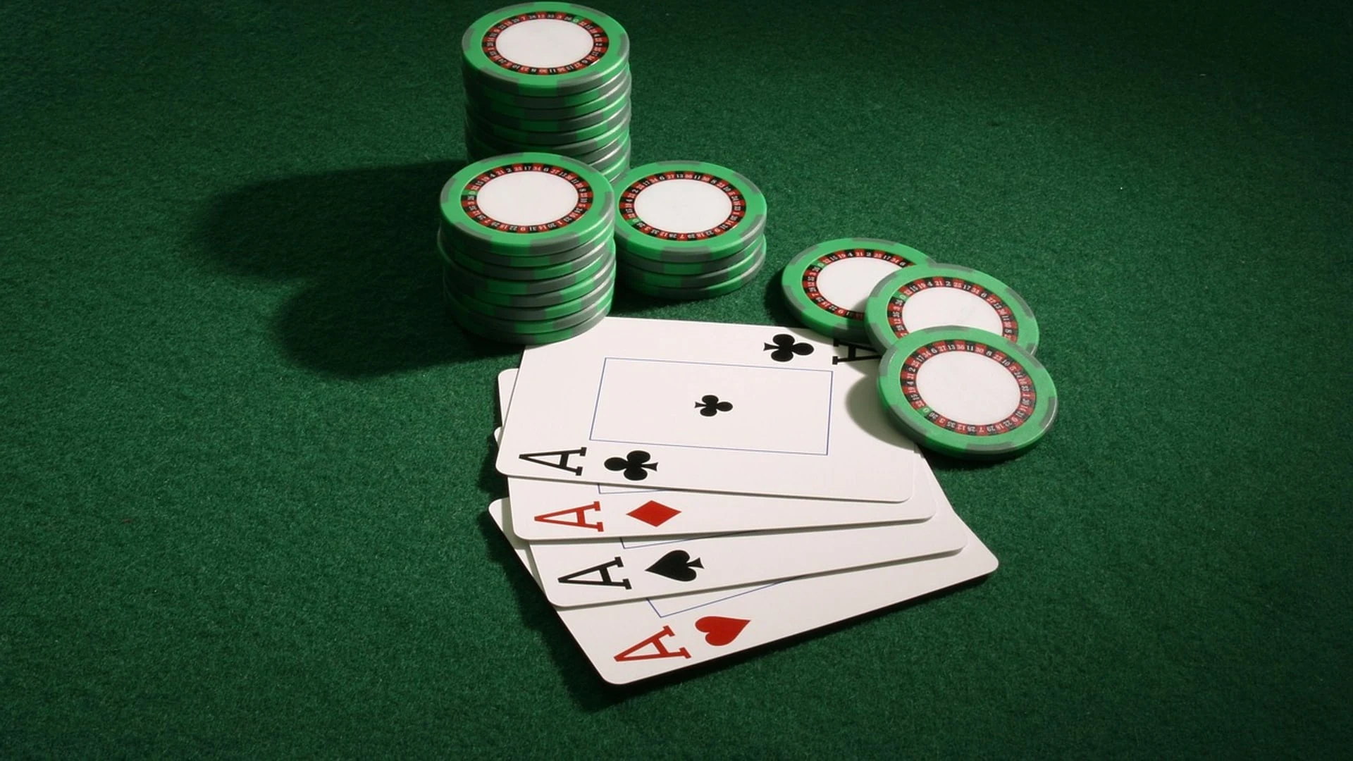 Pokerchips und Spielkarten auf einem grünen Casino-Tisch